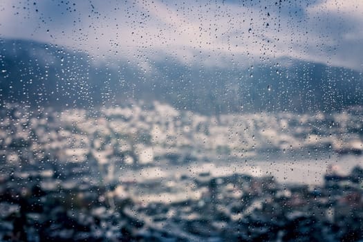 View of the Bergen town as seen through wet window during rainy weather, Norway