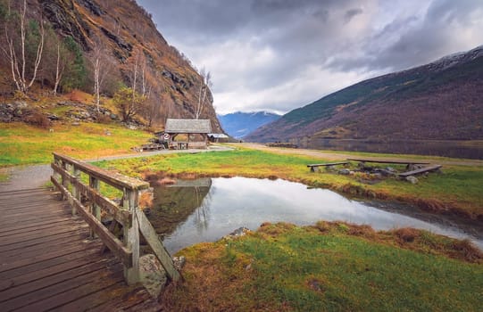 Small wooden bridge on a path leading to the fjord shore in small village Flam, Norway