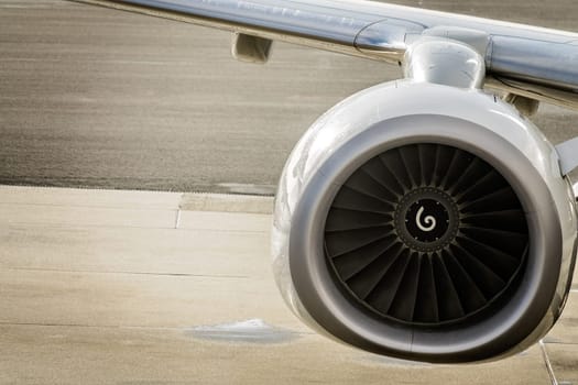 Close up shot of a jet engine of a modern airplane standing on a runway