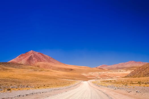 Sandy and gravel desert road through remote part of southern Altiplano, Bolivia