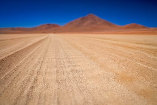 Gravel and corrugated desert road through remote part of southern Altiplano, Bolivia
