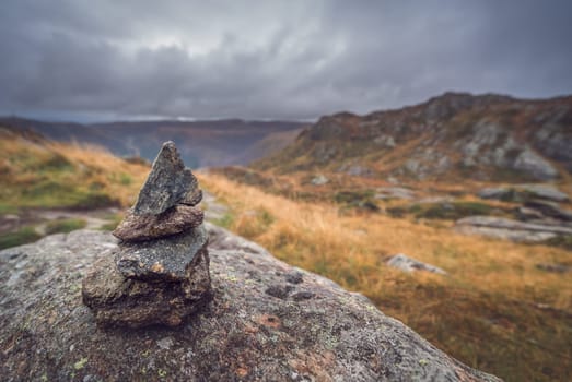 Zen balanced small pile of stacked stones on a walking path starting on top of Mount Ulriken in Bergen, Norway