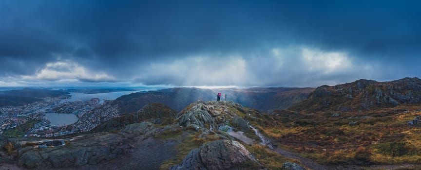 Unidentifiable tourists standing on the top of mount Ulriken in Bergen in loving embrace, Norway