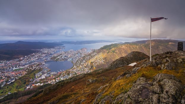 Norwegian flag fluttering on a wind on a pole on top of Mount Ulriken, Bergen, Norway