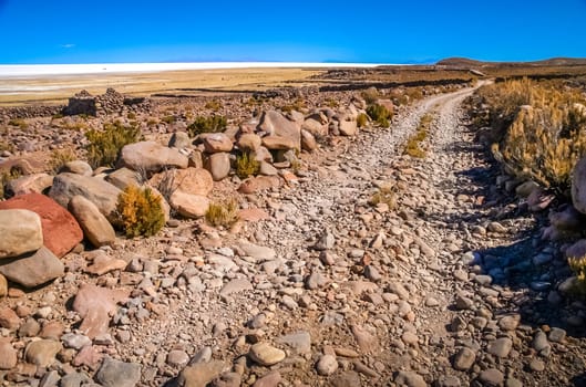 Remote road leading to the biggest of salt lakes, Salar de Uyuni in Bolivia
