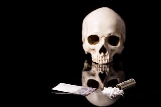cocaine, Herion or other illegal drugs that are sniffed by means of a tube or injected with a syringe, money and Skull, isolated on black glossy background