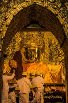 Early morning brushing the teeth of Mahamuni Buddha in Mandalay, Myanmar
