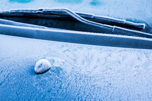 Iceflowers, frozen.The ice-cold frost forms ice crystals in beautiful unique patterns on the window, Hood and wiper on the Car