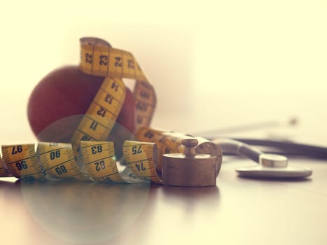 Healthy food concept with an organic apple and a stethoscope on a wooden table
