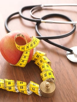 Healthy food concept with an organic apple and a stethoscope on a wooden table