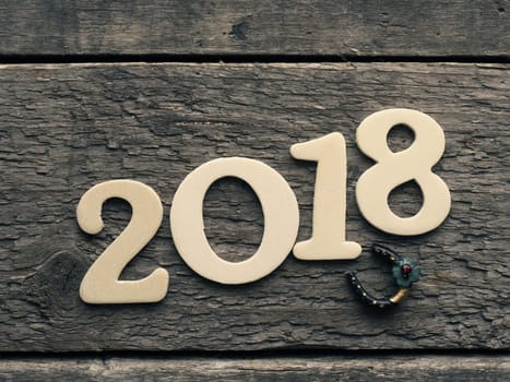 New Year 2018 with a horse shoe on a rustic wooden plank, Happy New Year and Good luck