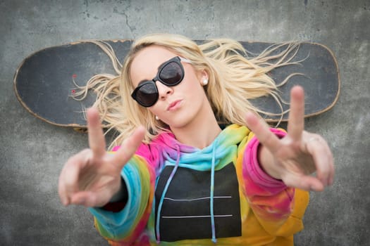 Blond teen skater girl giving peace sign