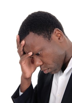 A frustrated African American man in a suit with his hand on his face.looking down in depression, isolated for white background.