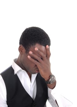 A young African American ma in a vest with his hand over his face.is frustrated about his situation, isolated for white background.