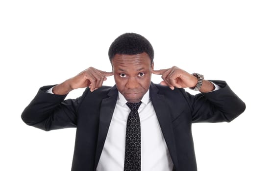 An African American man in a suit in close up putting his fingers in his.ears, don’t like to hear, isolated for white background.