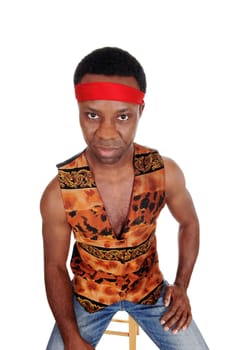 A handsome African American man sitting in a vest and red headband, .looking angry, isolated for white background.