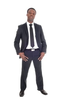 A tall handsome African American man standing in a dark suit nad tie.with his thump's in his poket, isolated foe white background.