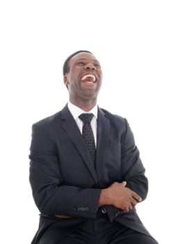 A happyly laughing African American man sitting on a chair with his.head back and mouth open, isolated for white background.