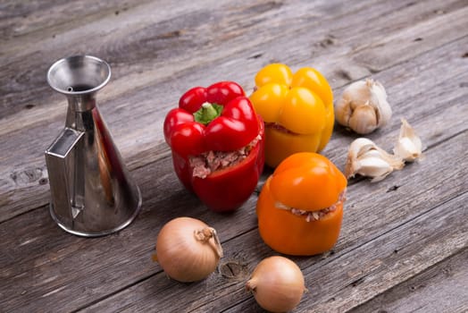 colorful filled pepper,oil,garlic and onion on wooden ground