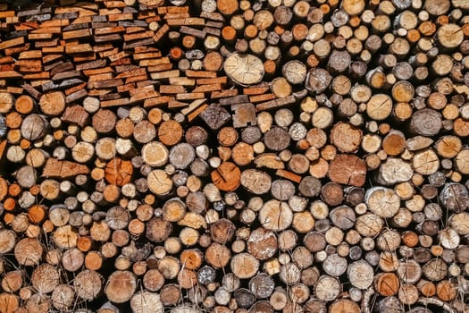 Firewood logs stacked in piles outside cottage