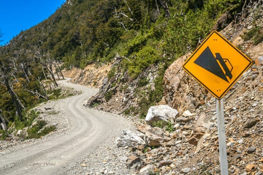 Dangerous steep winding gravel mountain road uphill