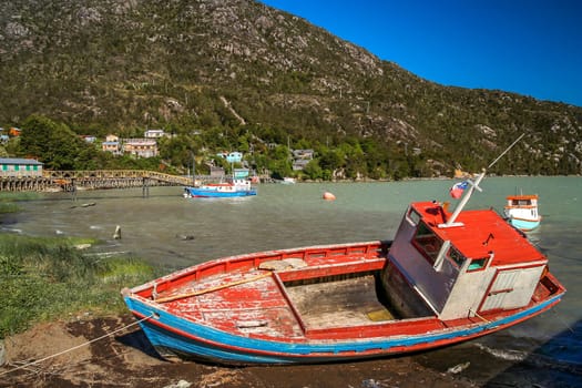 Disused fishing boat on the riverbank in Patagonian Andes