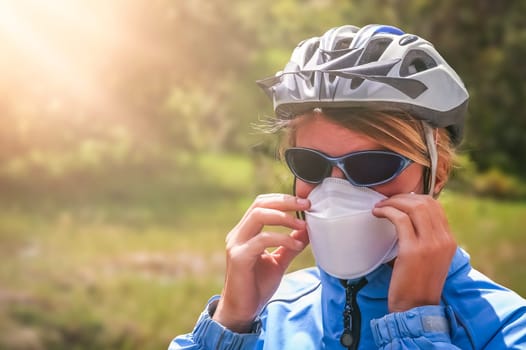 Female cyclist wearing a protective face mask preventing from breathing in volcanic dust ash after eruption in southern Patagonia, Chile