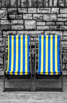 Empty yellow and blue striped deckchairs, Bournemouth, England