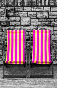 Empty purple and yellow striped deckchairs, Bournemouth, England