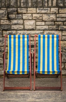 Empty yellow and blue striped deckchairs, Bournemouth, England
