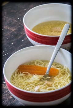 Chicken broth soup in a bowl on a table