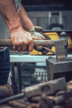 A blacksmith hammering hot iron during medieval fair festival in Streatham Park in London