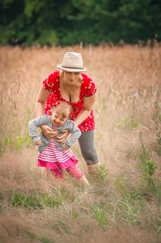 Mother and daughter playing together on a meadow