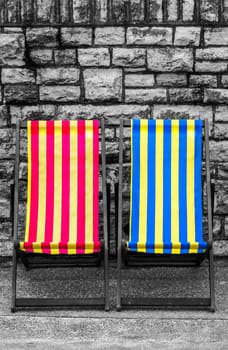 Empty red, blue and yellow striped deckchairs, Bournemouth, England
