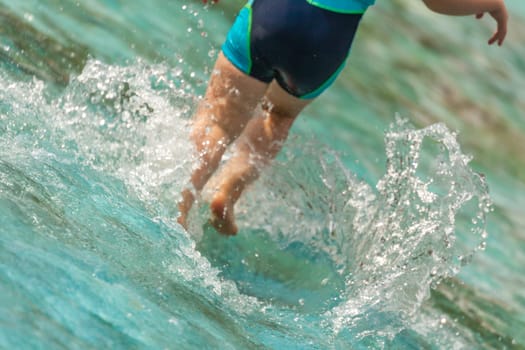 Little girl walking in water in the kids pool in the summer