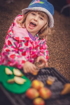 Portrait of a cute little girl tasting fresh organic apple juice at a local farmers market
