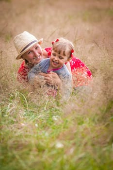 Mother and daughter playing together on a meadow