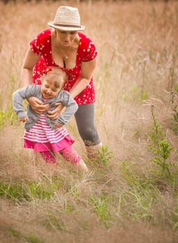 Mother and daughter playing together on a meadow
