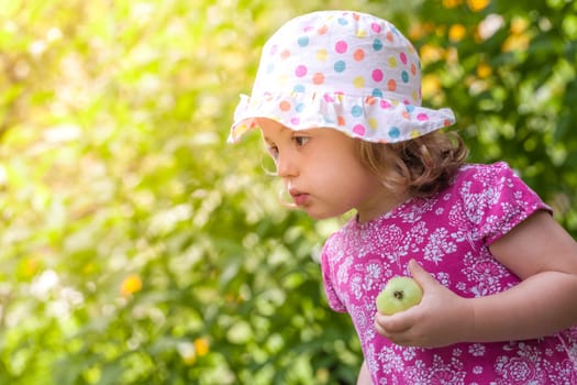 Cute little girl holding half eaten apple