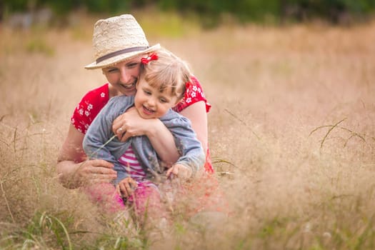Mother and daughter playing together on a meadow