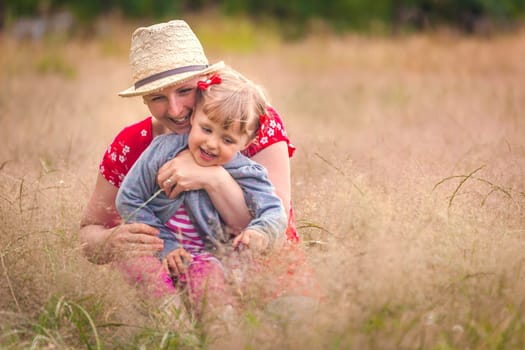 Mother and daughter playing together on a meadow