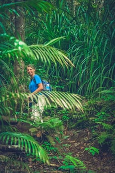 Girl walking up the jungle path to the summit of Gunung Rinjani volcano in Lombok, Indonesia