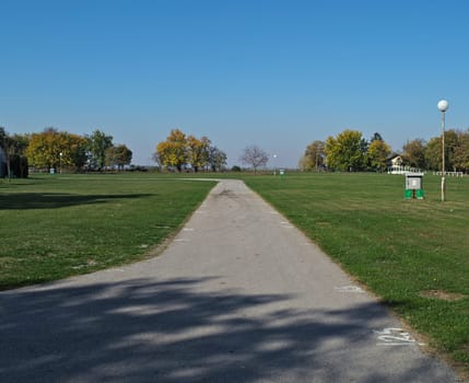 Asphalt path in hippodrome on a sunny autumn day