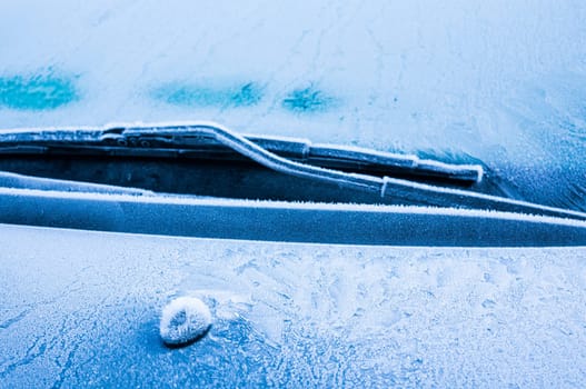 Iceflowers, frozen.The ice-cold frost forms ice crystals in beautiful unique patterns on the window, Hood and wiper on the Car