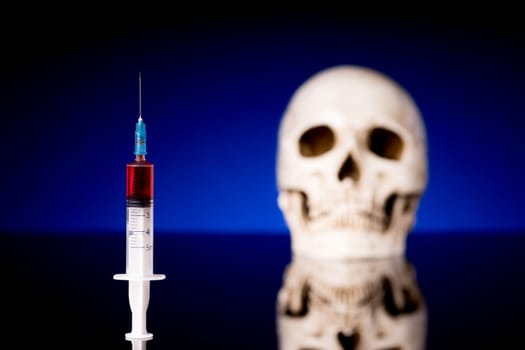 Blurry Skull and syringe, isolated on black blue background with glossy reflection