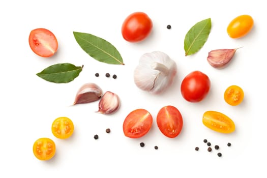 tomatoes,garlic,bay leaves and peppercorn isolated on white background. top view