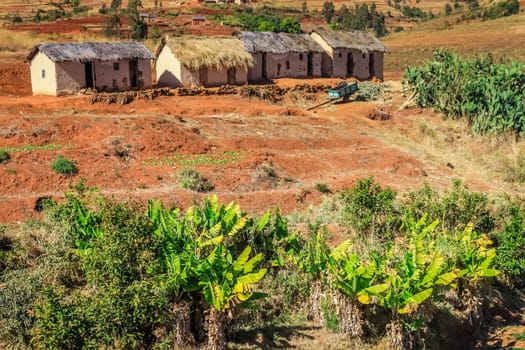 Row of four primitive huts in central plateau in Madagascar