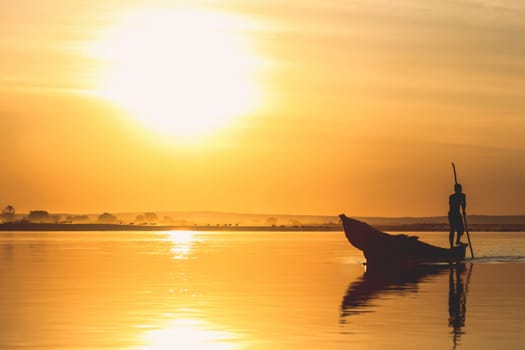 Traditional fishing pirogue at sunset on the Tsiribihina river in Madagascar