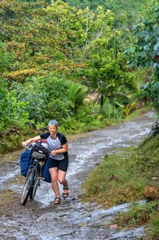 Cyclist struggling with bicycle on difficult jungle track towards Mananara on the Vanilla Coast in Madagascar
