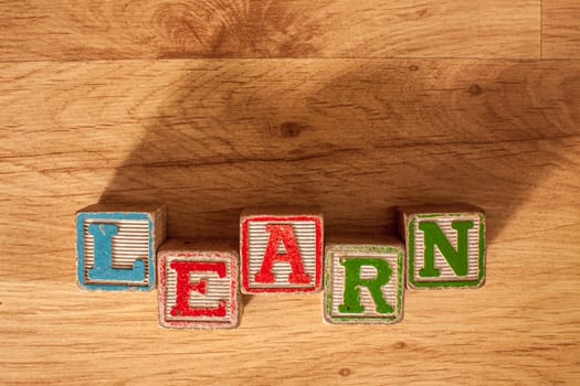 Vintage Wooden Childrens Blocks spell out the word Learn